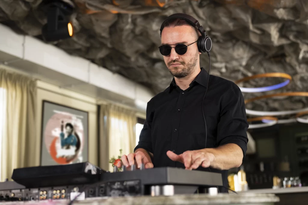 DJ usando audífonos mientras mezcla música en una consola profesional